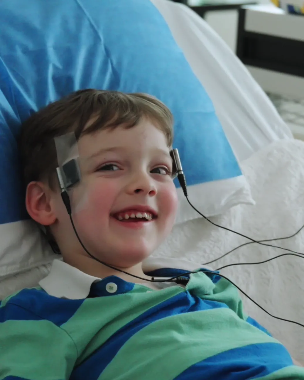 Child smiling during a monitored session at Neorgana